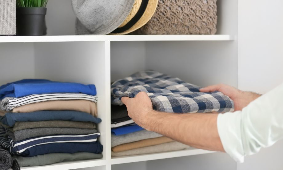 Sweaters folded on closet shelf